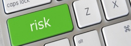 Close up of computer keyboard highlighting a key that say "risk"
