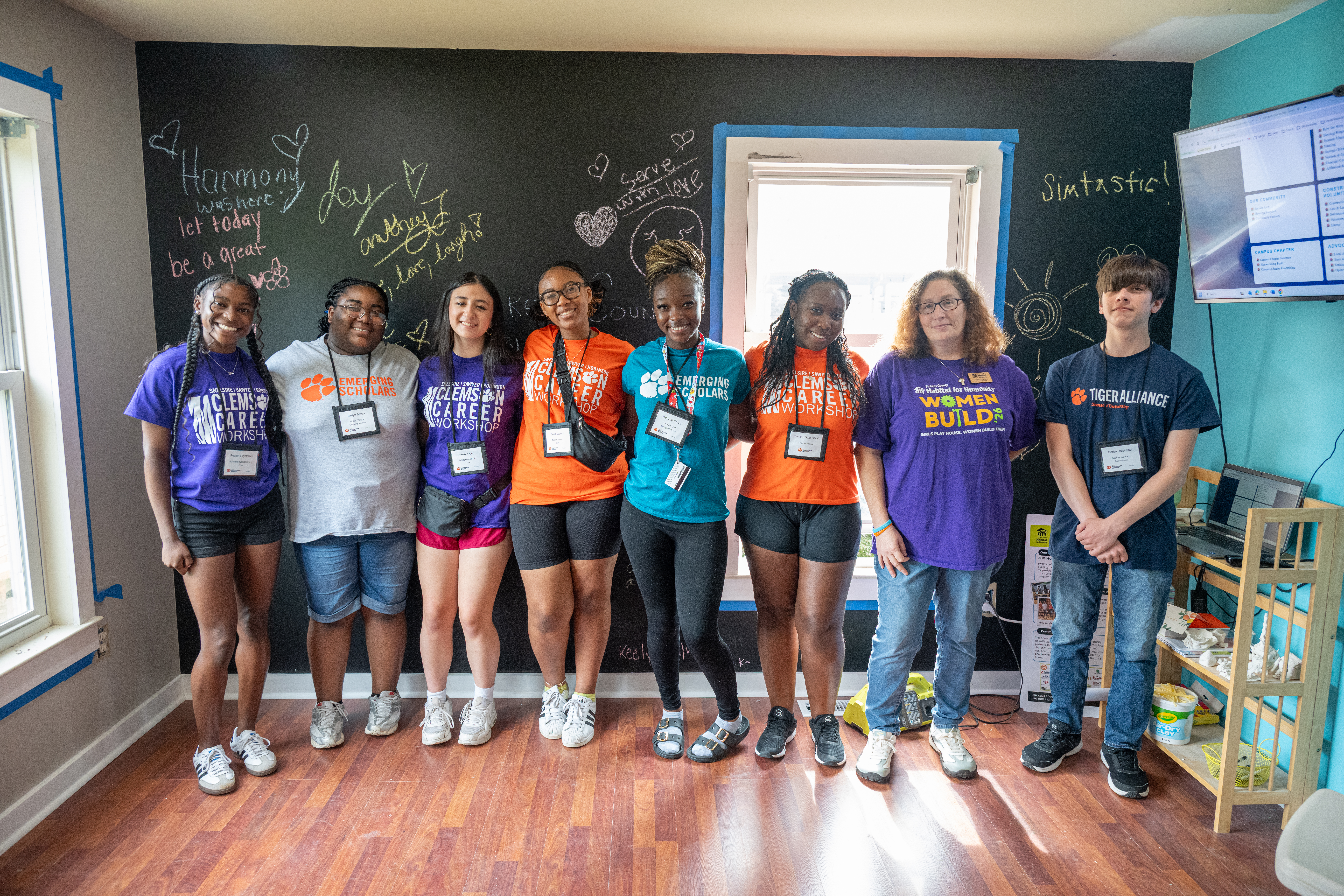 students posing together in different program shirts after a community service project