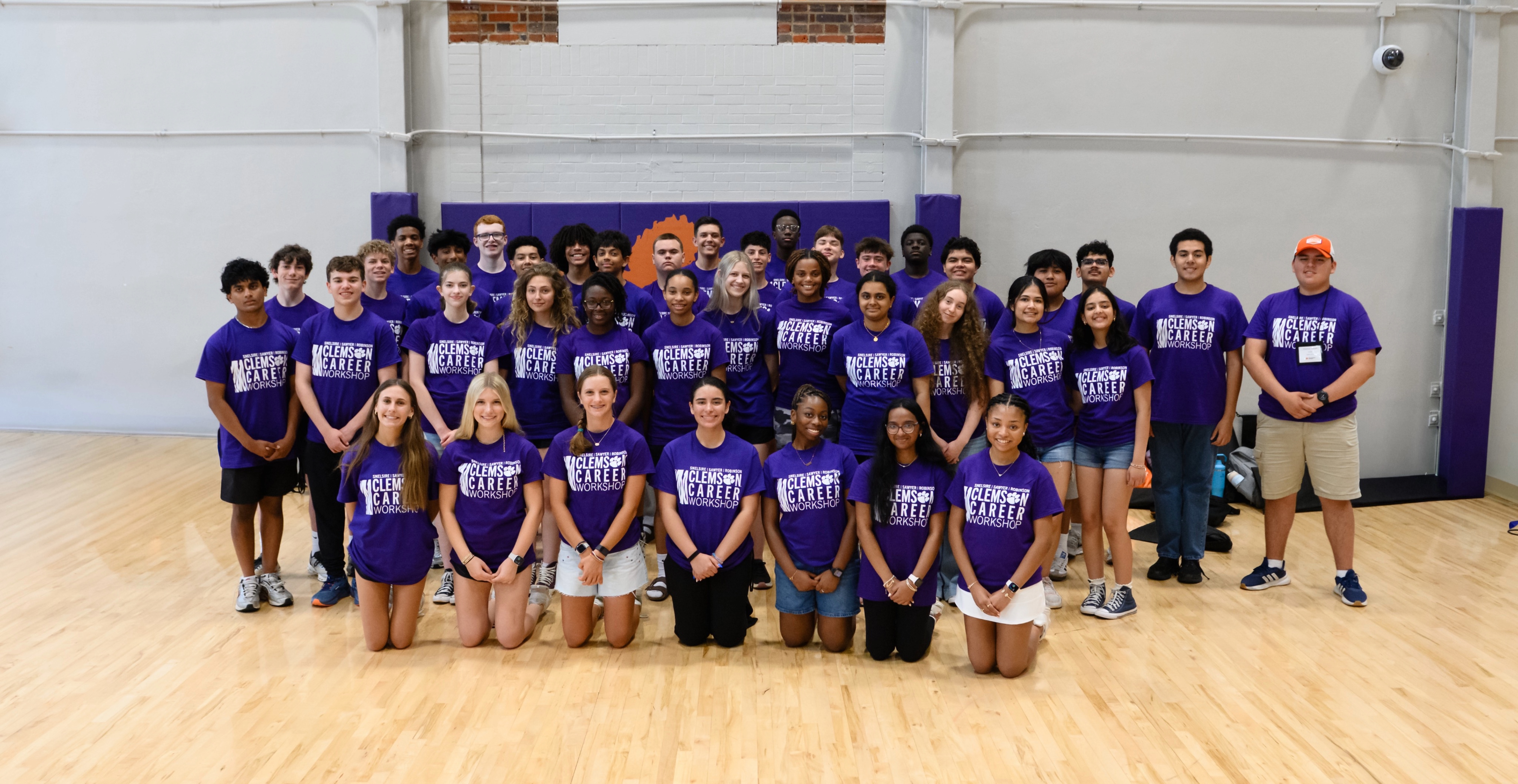 Group photo of students in purple "Clemson Career Workshop" T-shirts posing in a gymnasium.