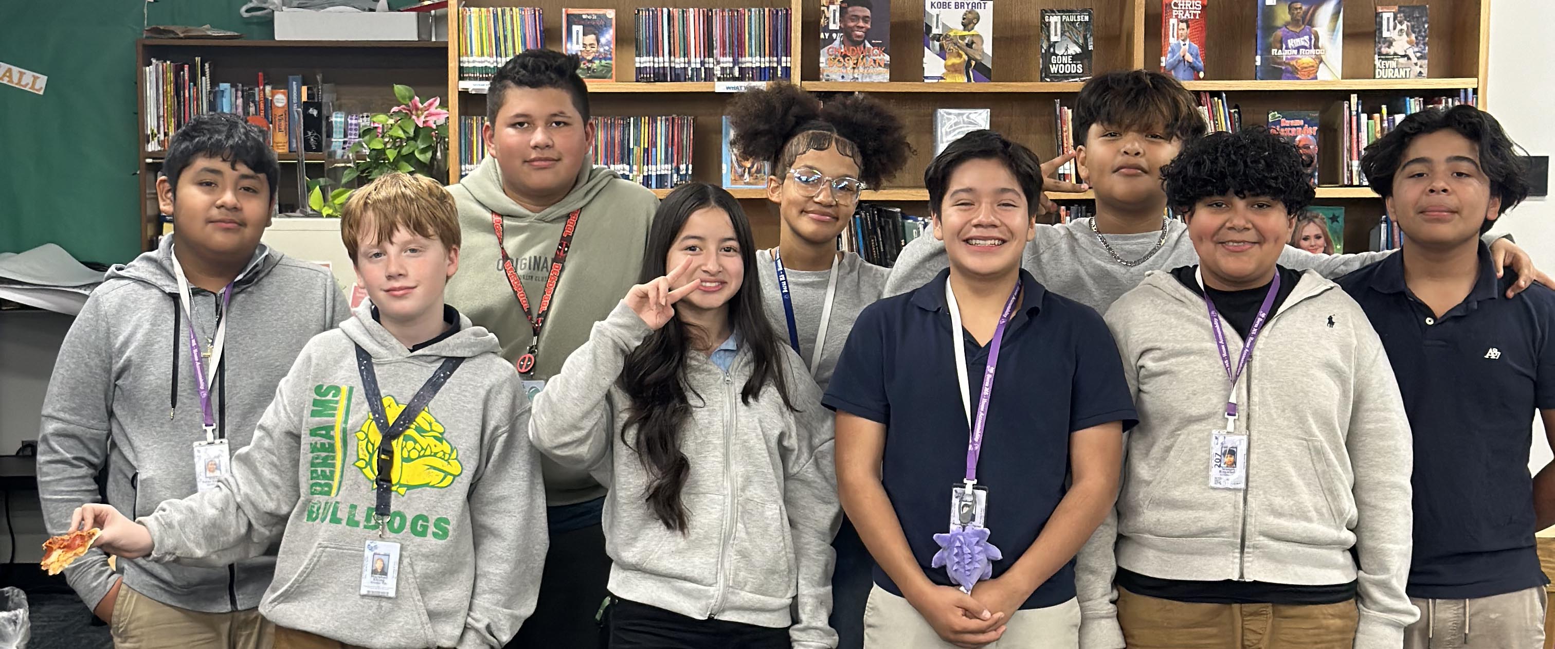A group of students pose together in a classroom