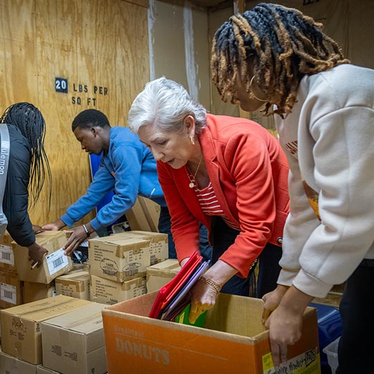 A group of volunteers pack cardboard boxes