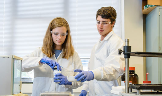 2 Students measuring powder in lab