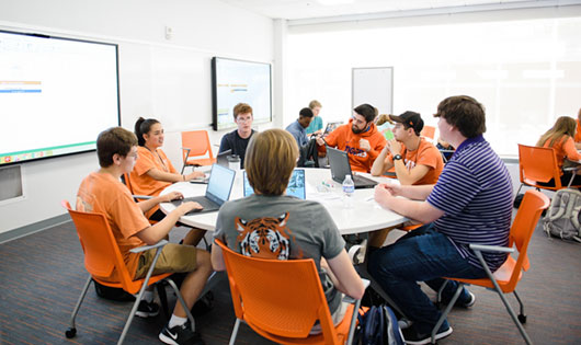 Students at round table working on project