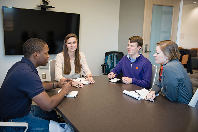 Committee of students sitting around a table.