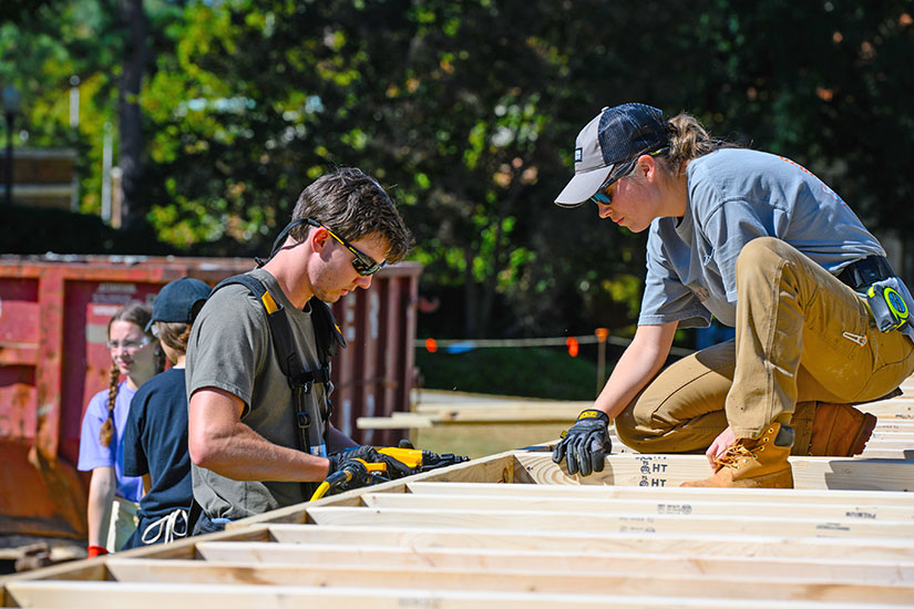 Male and female student working to build Habitat For Humanity house.