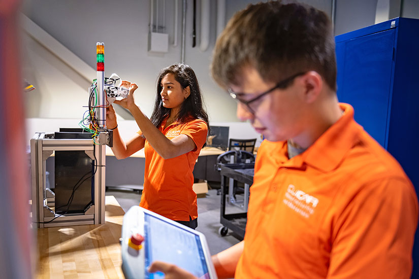 Two students at CUICAR campus working on equipment.