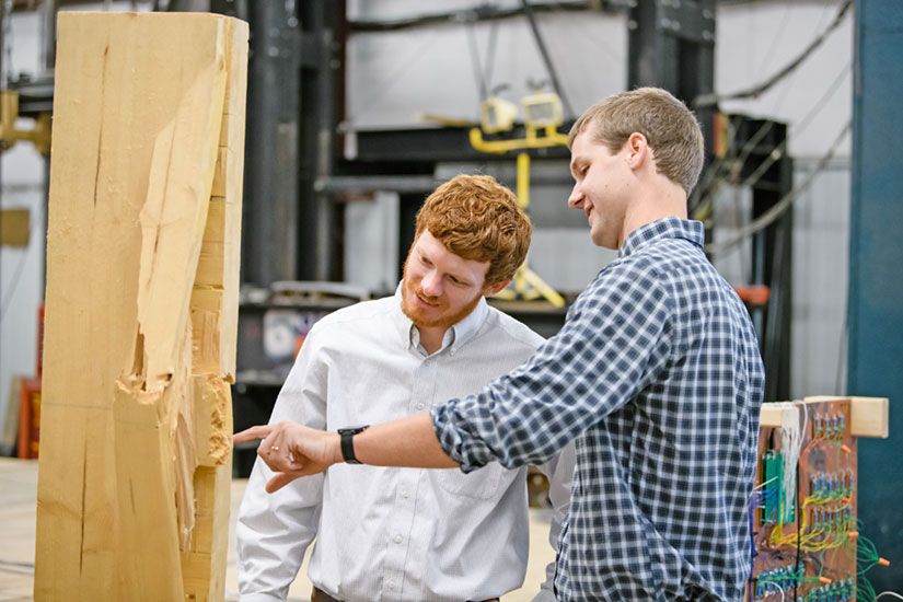 Two students inspecting wood grain