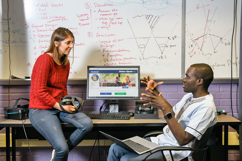 Two students at computer talking