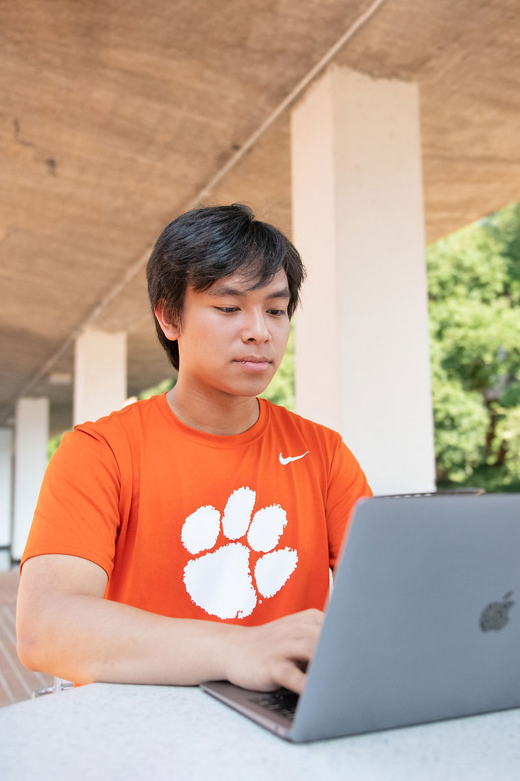 Student on laptop by library