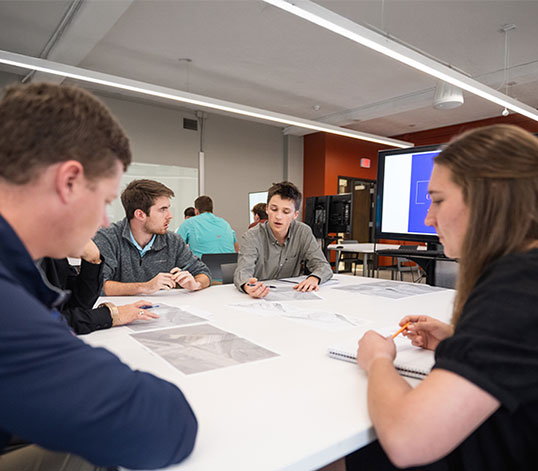 Students discussing capstone at table