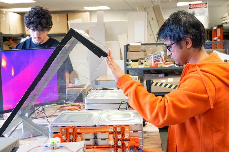 Two students working at a counter on vehicle concepts
