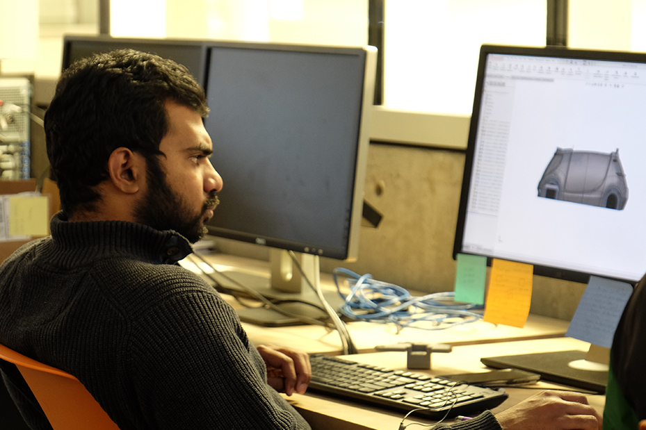 Student studies a rendering of the concept vehicle