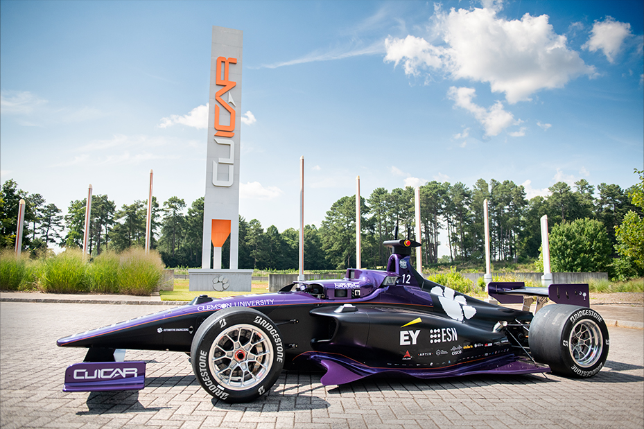 Completed DO12 Autonomous Indy Car sits in front of CU-ICAR sign