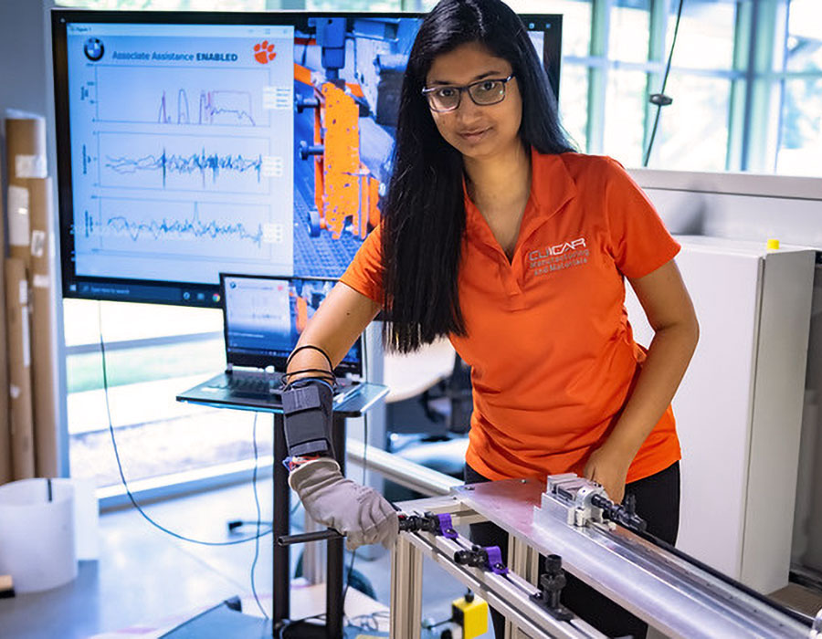 Female graduate student utilizing tech glove to assist with project.