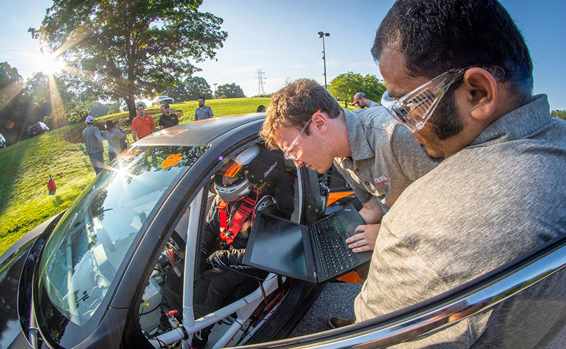 Students assisting with Deep Orange 9 vehicle.