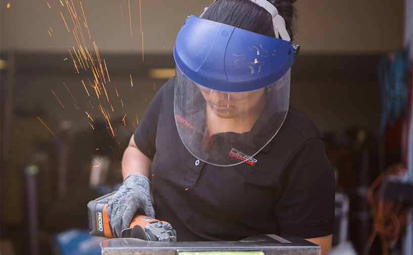 Female student using grinding tool.