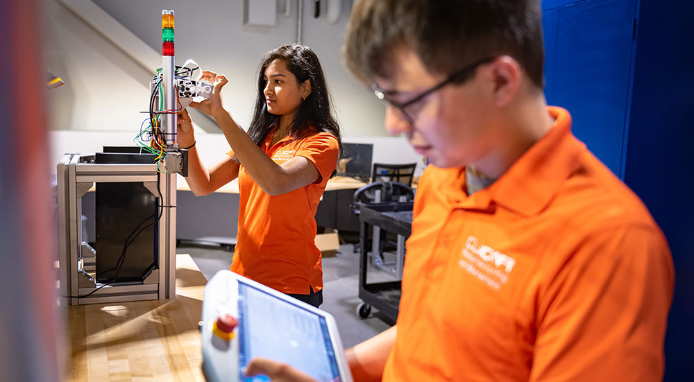 Two students on the CUICAR campus working with equipment.