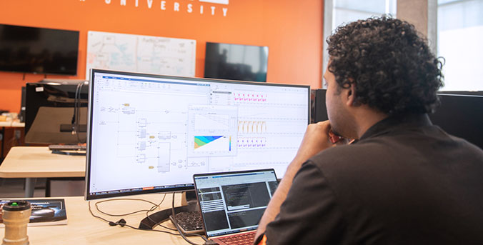 Student at computer looking at diagrams.