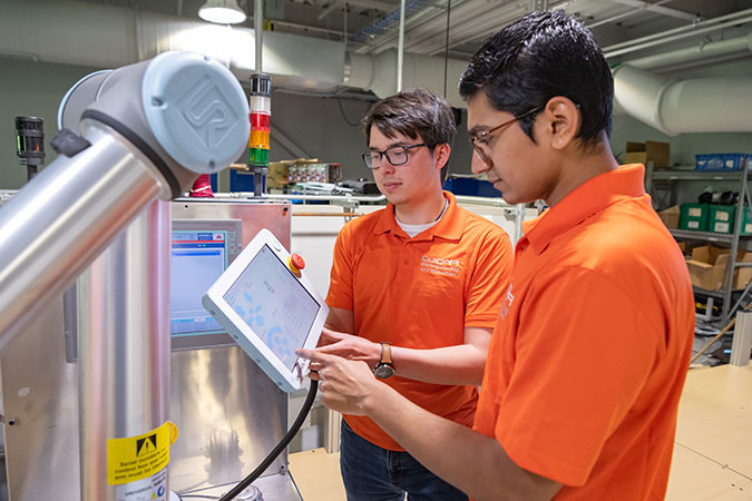 Two students using pad and tech arm.