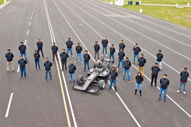Group at Indy track with car.