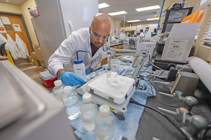 Student in lab with additional students in the background