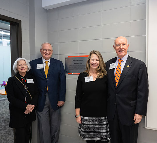 Brown and family beside plaque in Lowry.