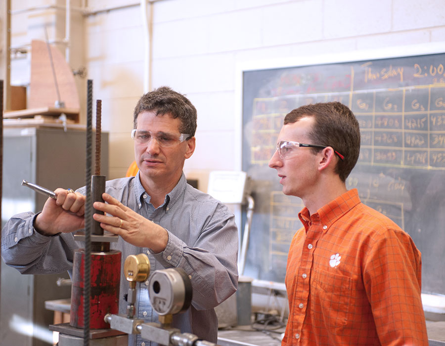 faculty member in lab demonstrating equipment to undergraduate student.