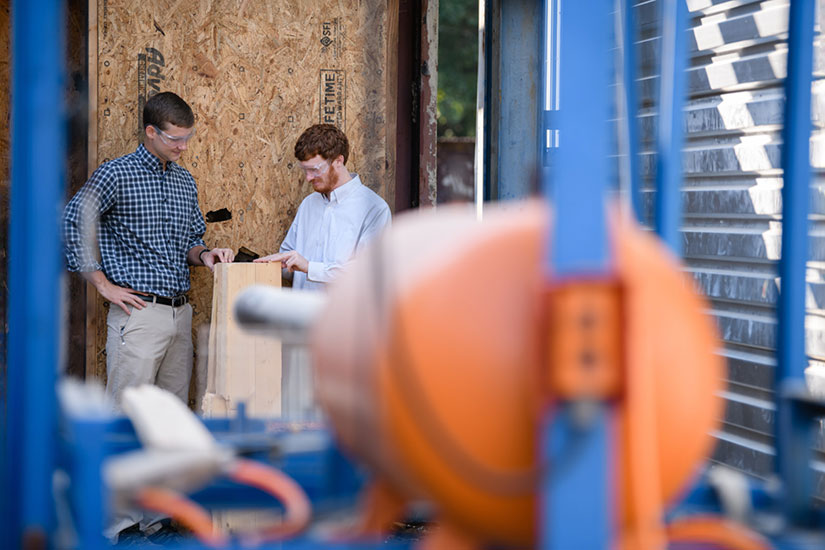 Two students looking at timber.