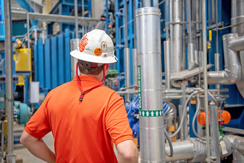 Employee in hard hat in campus Heat Plant.