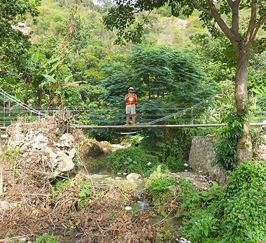 Male student with Tiger Rag on bridge in Haiti.