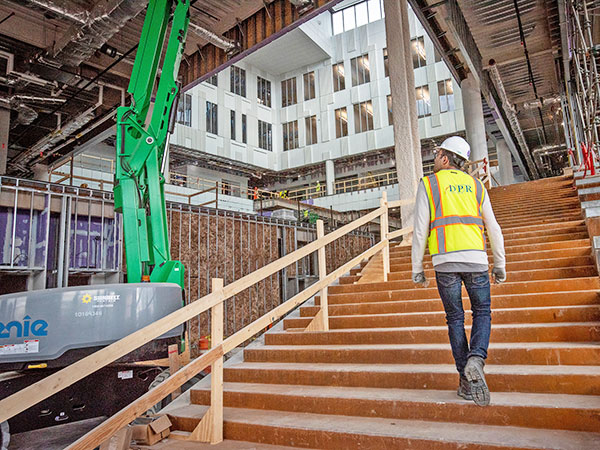 Graduate student looking up inside new building construction.