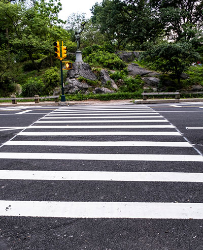 Crosswalk with traffic light seen across the street.