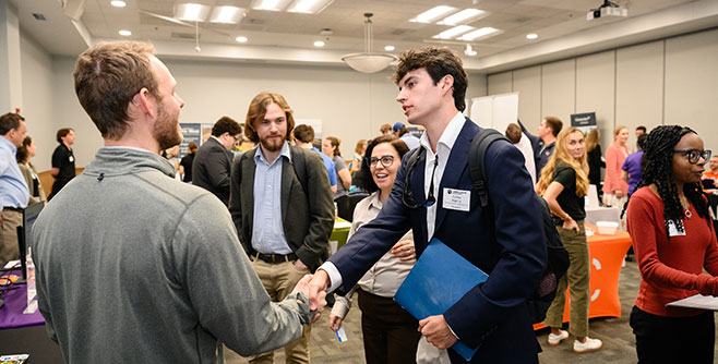 Student shaking hands with industry member at career fair