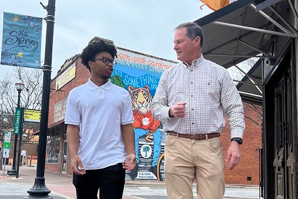 Civil engineering alumnus Tom Rochester (right) walks through downtown Clemson with civil engineering major Jemal Scarborough.