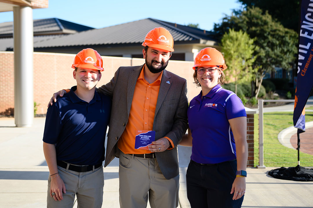 Forghanparast standing with two students while at the annual Hard Hat Ceremony.