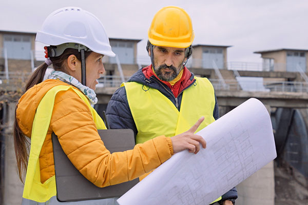 Professional engineer and intern on job site.