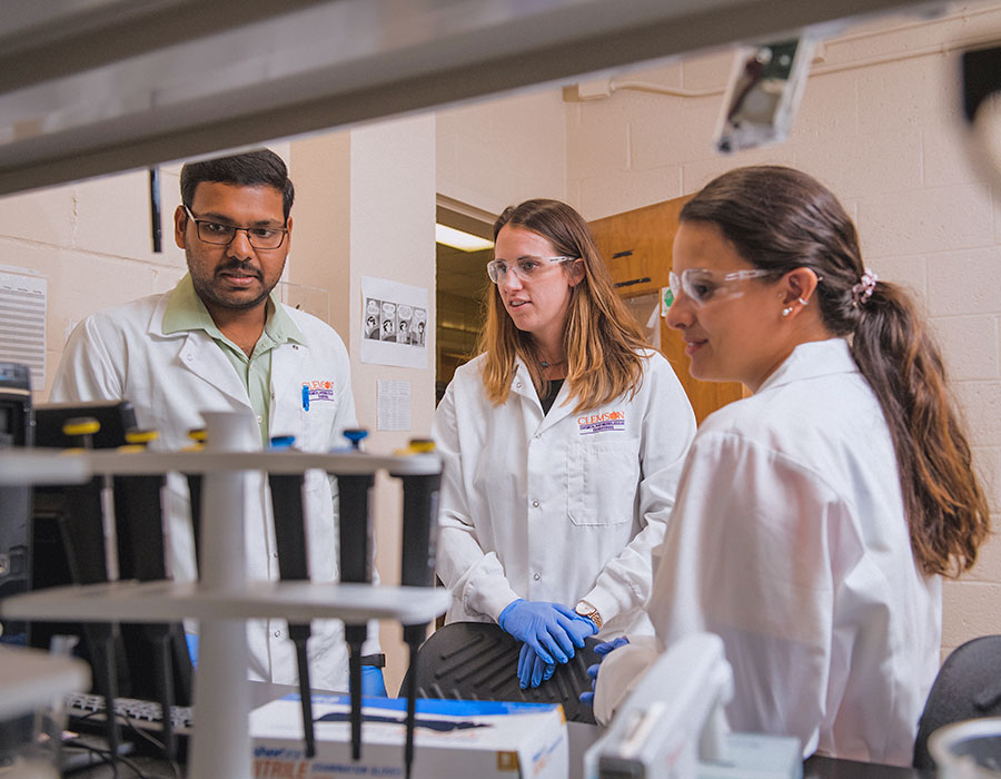 Male and female student with Larsen in lab.