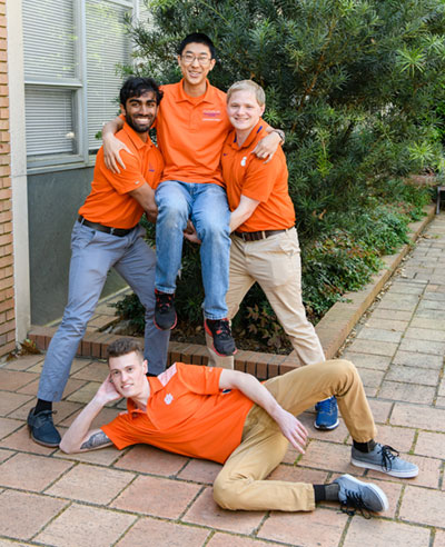 4 students posing in front of Earle Hall