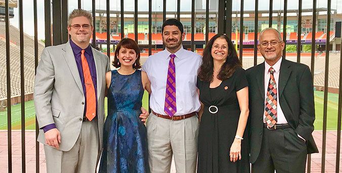 Outstanding alumni Arms with family outside stadium.