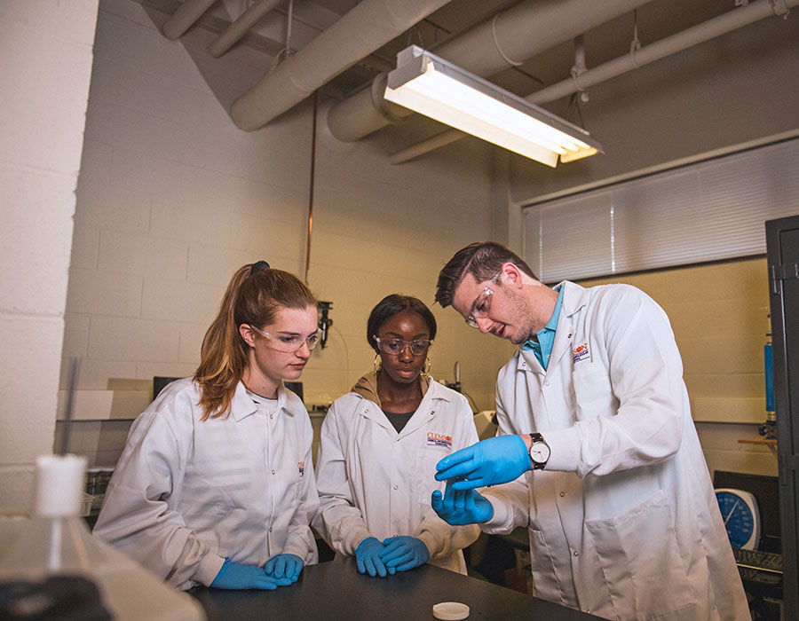 2 Female students with Eric Davis in lab.