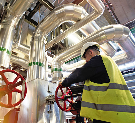 Man in chemical plant turning valve.