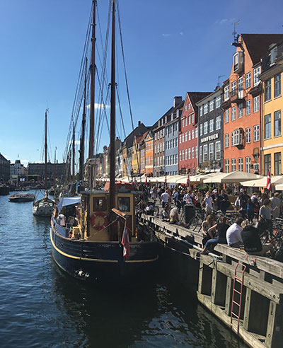 Harbor in Denmark with boats and row houses.