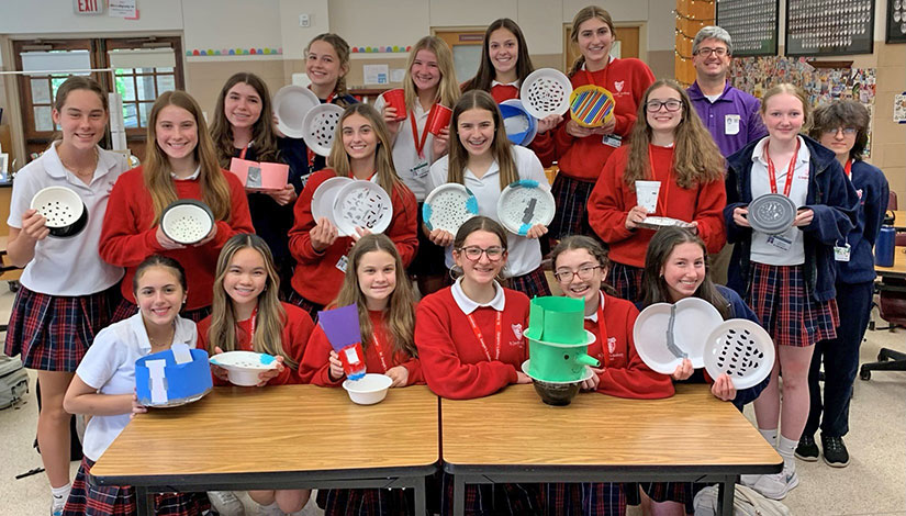 Group of students in classroom all showing their end results from the plates and pasta activity.