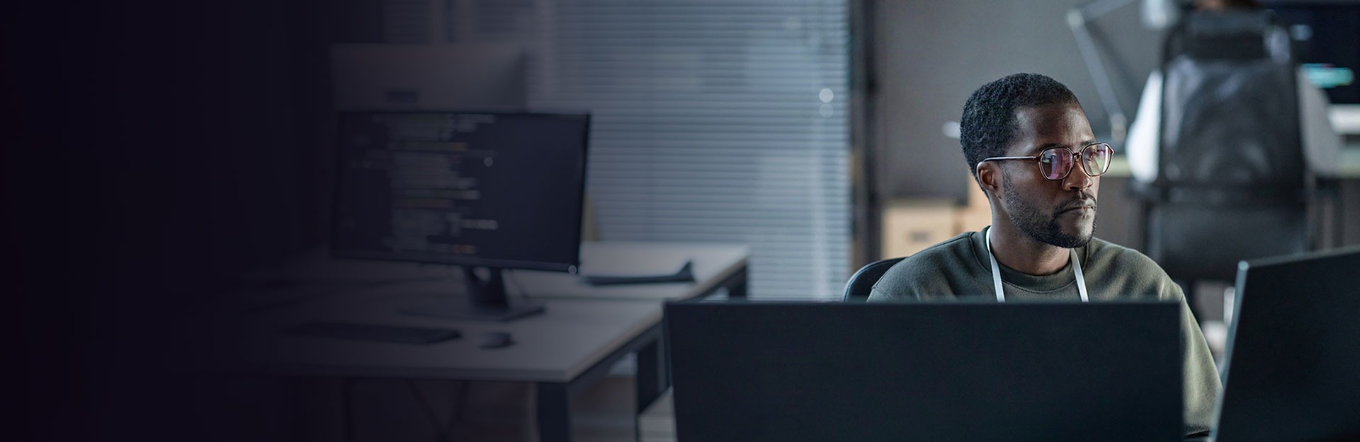 Man in office who is looking at his laptop, concentrating on work.