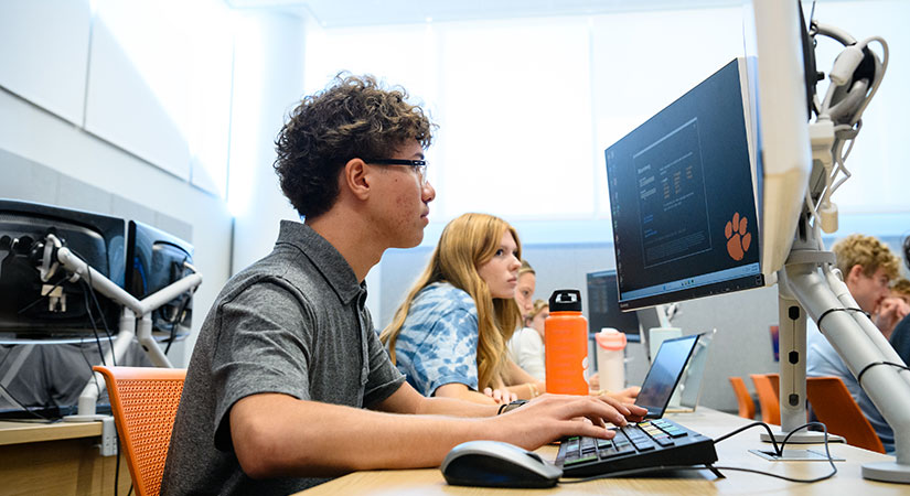 Student at desktop computer in class, ready to begin.
