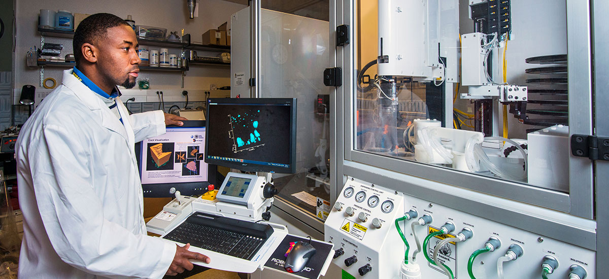 Male in lab room operating medical equipment