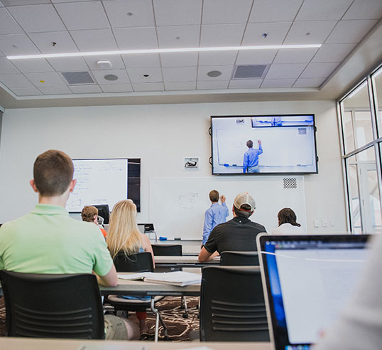 Female in front of screen presenting