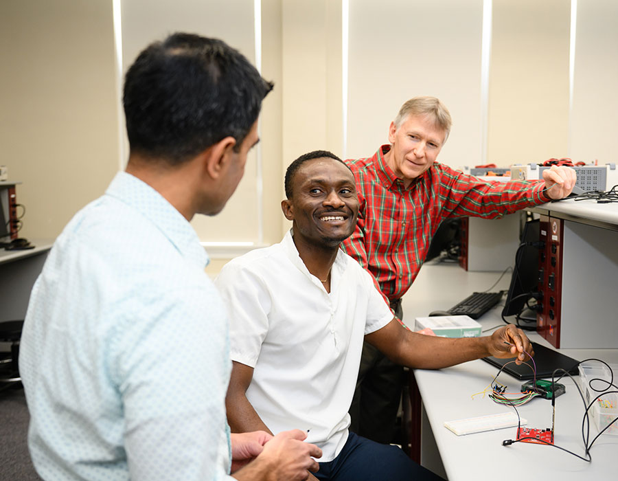 Two faculty members discussing research with graduate student