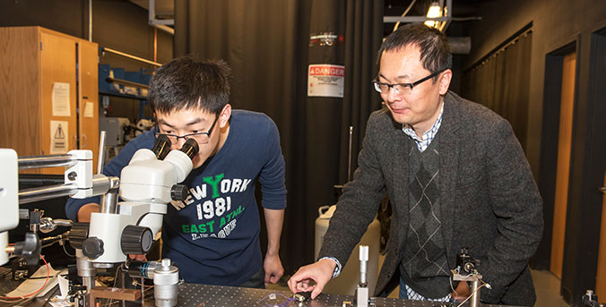 Lin Zhu with student in lab