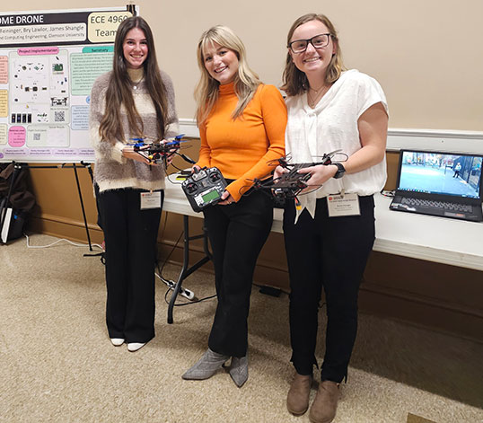 trio showing their design in Riggs Hall
